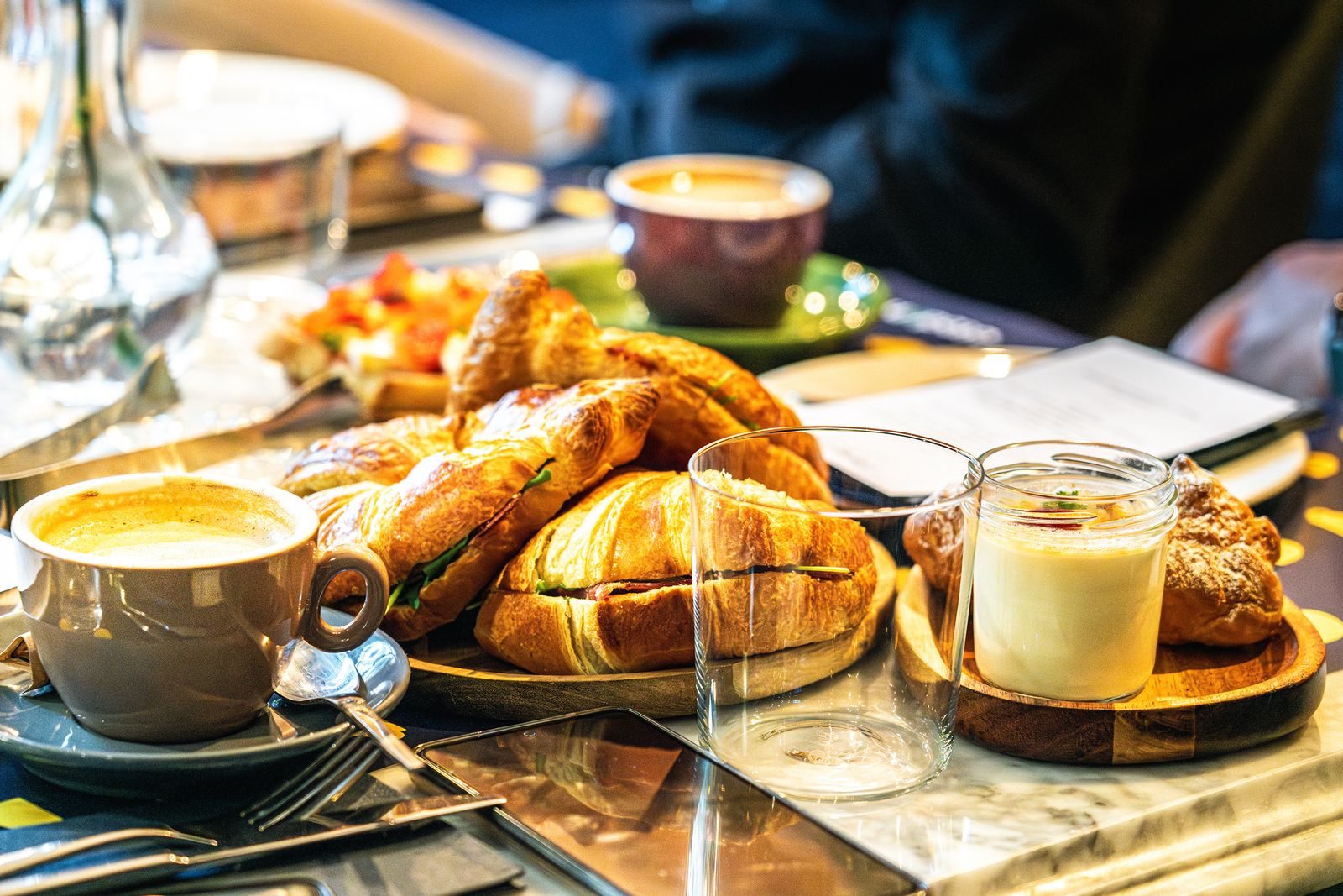 Colazione con caffè, cornetti e piccoli vasetti sul tavolo