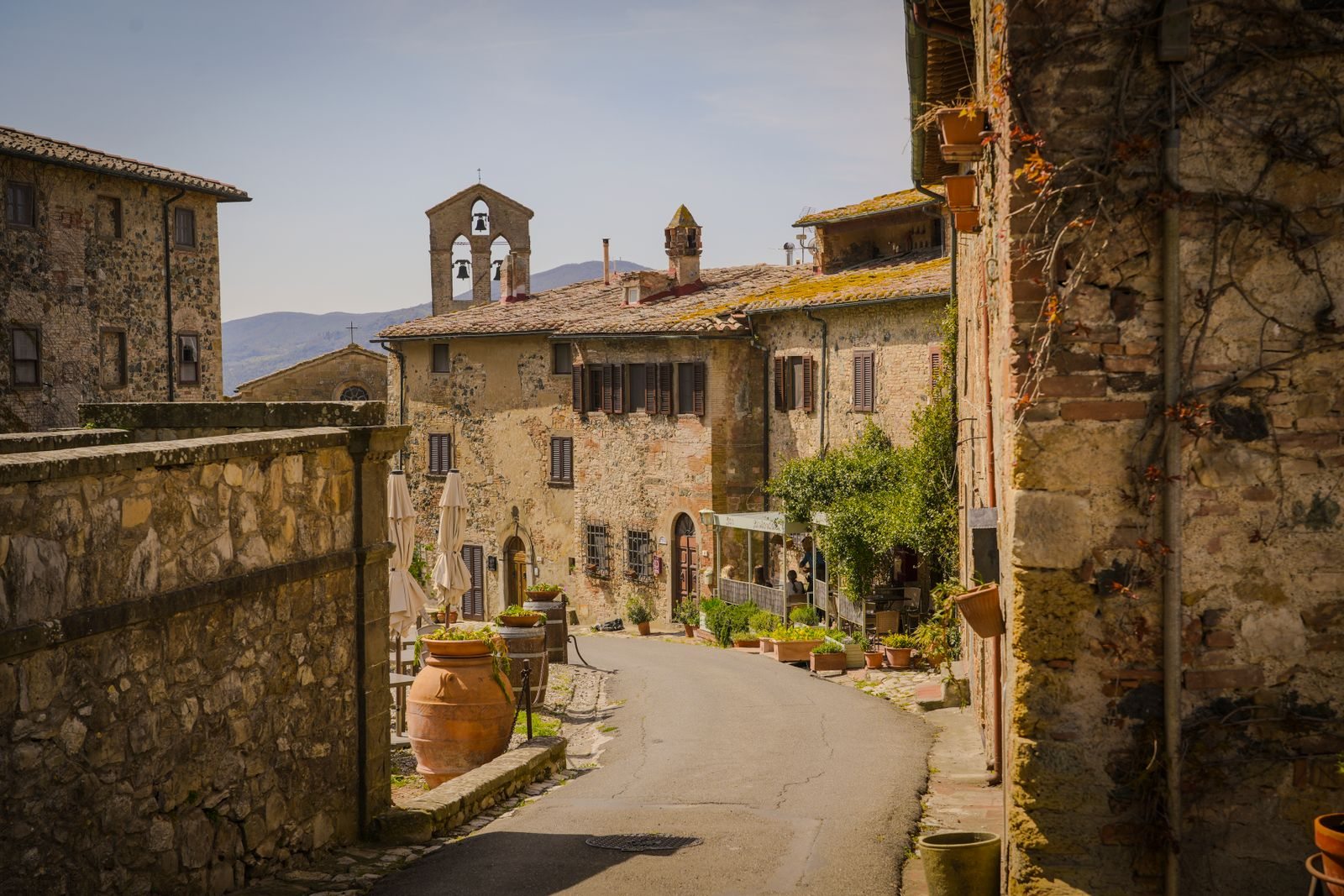 Strada tra edifici e giardini di un borgo toscano