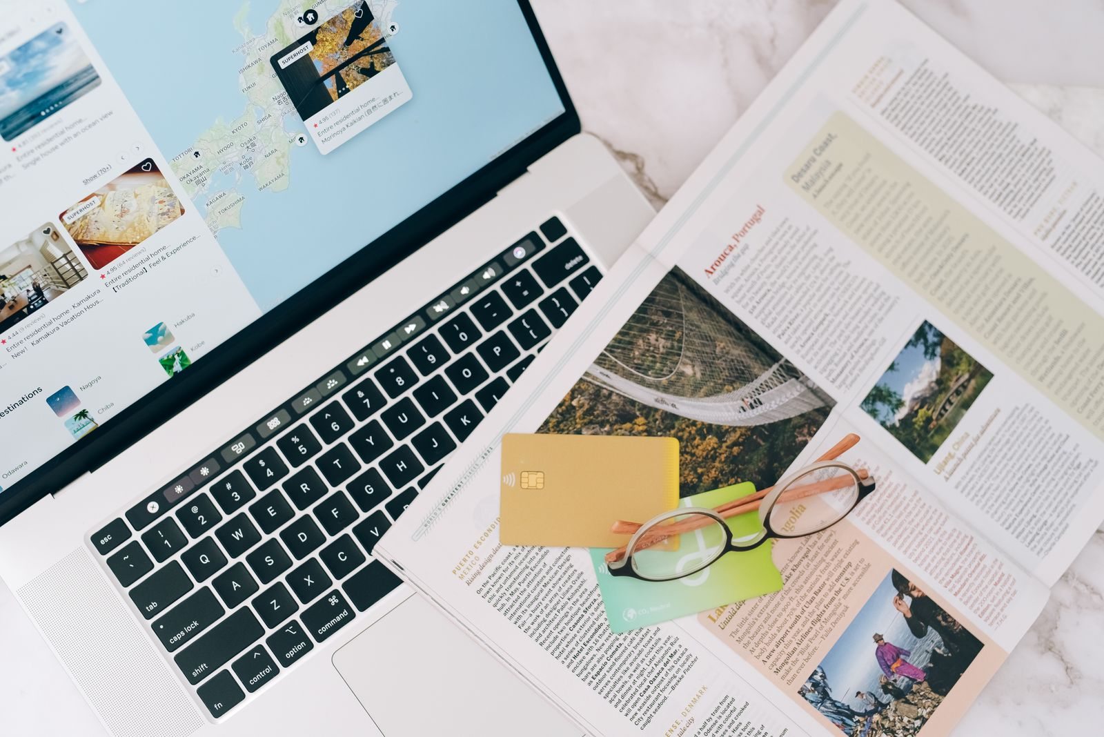 Computer portatile, rivista e carte su un tavolo