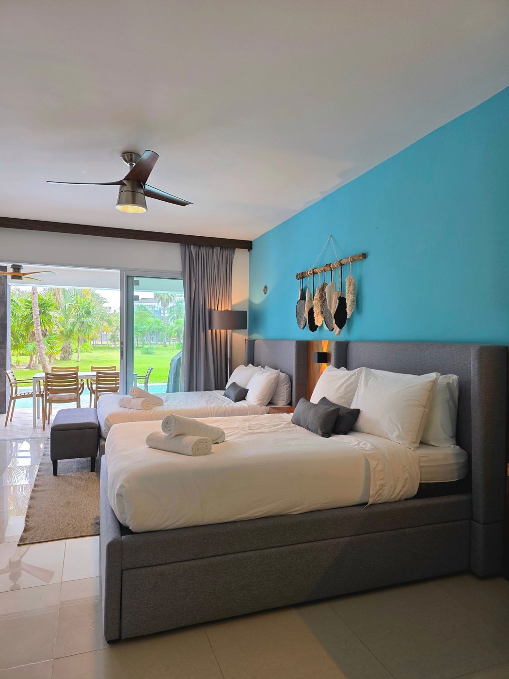 A room with twin beds and an opening onto a balcony