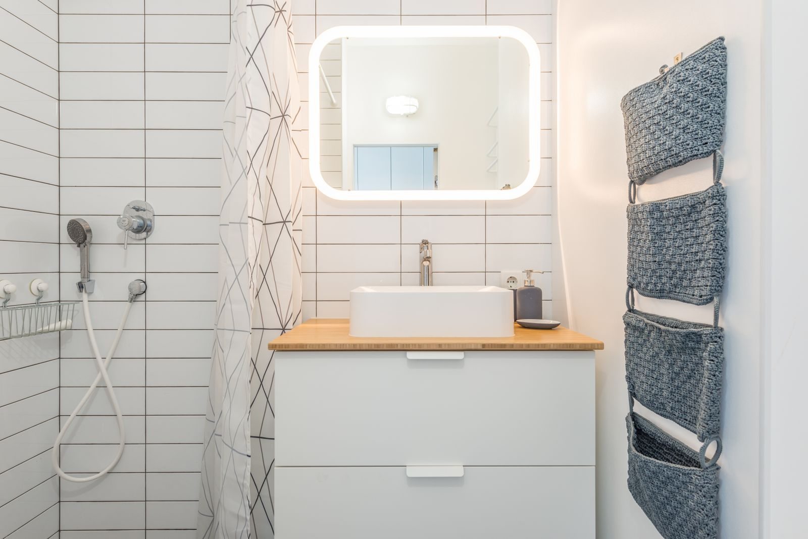 Piccolo bagno con doccia, lavabo e specchio
