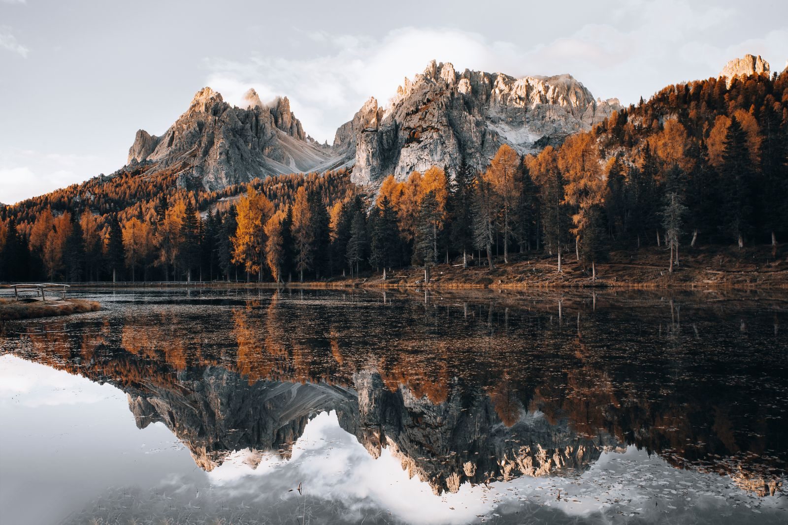 Alberi autunnali e montagne riflesse in un lago