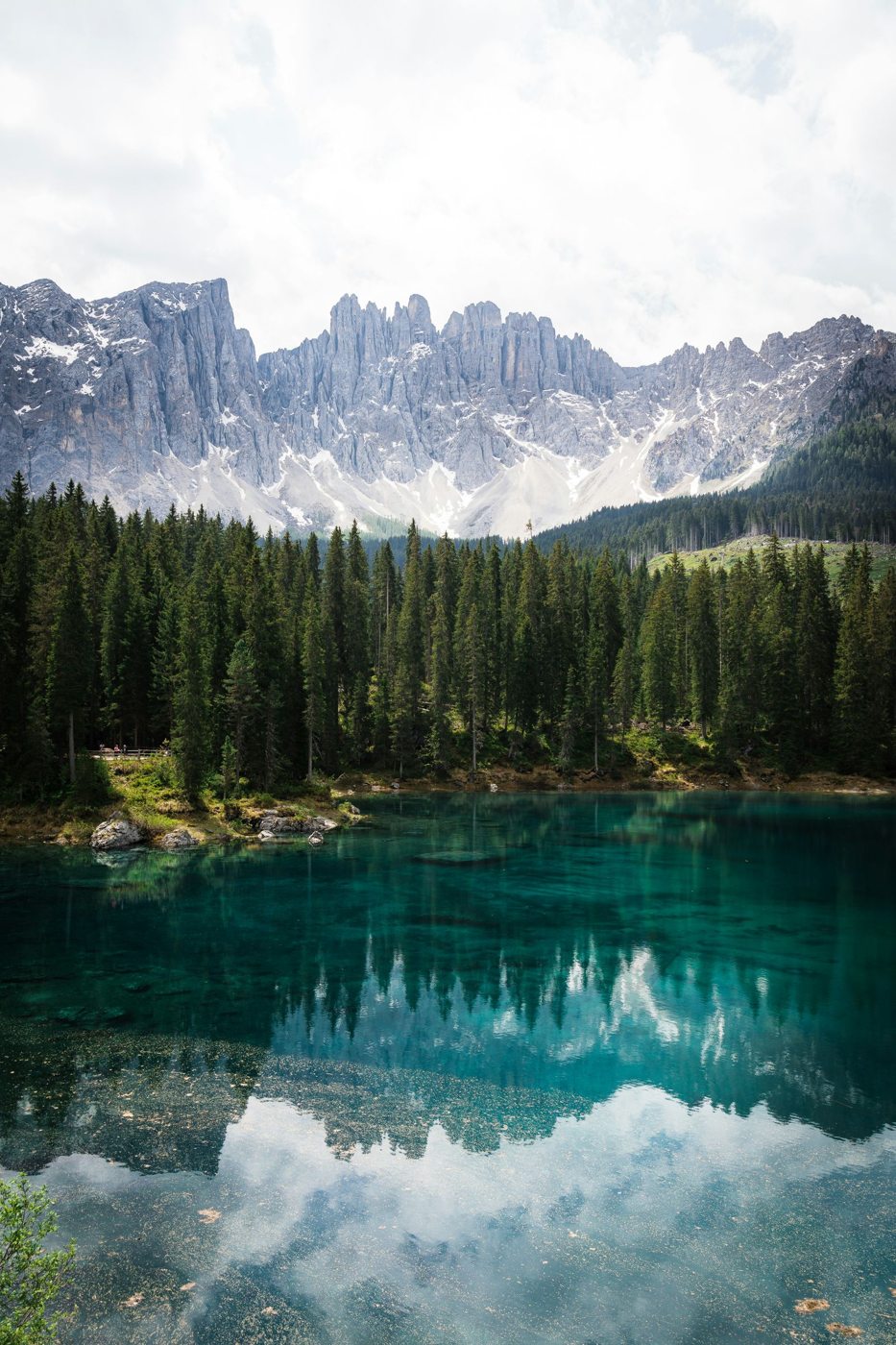 Il Lago di Carezza con bosco e montagne riflesse
