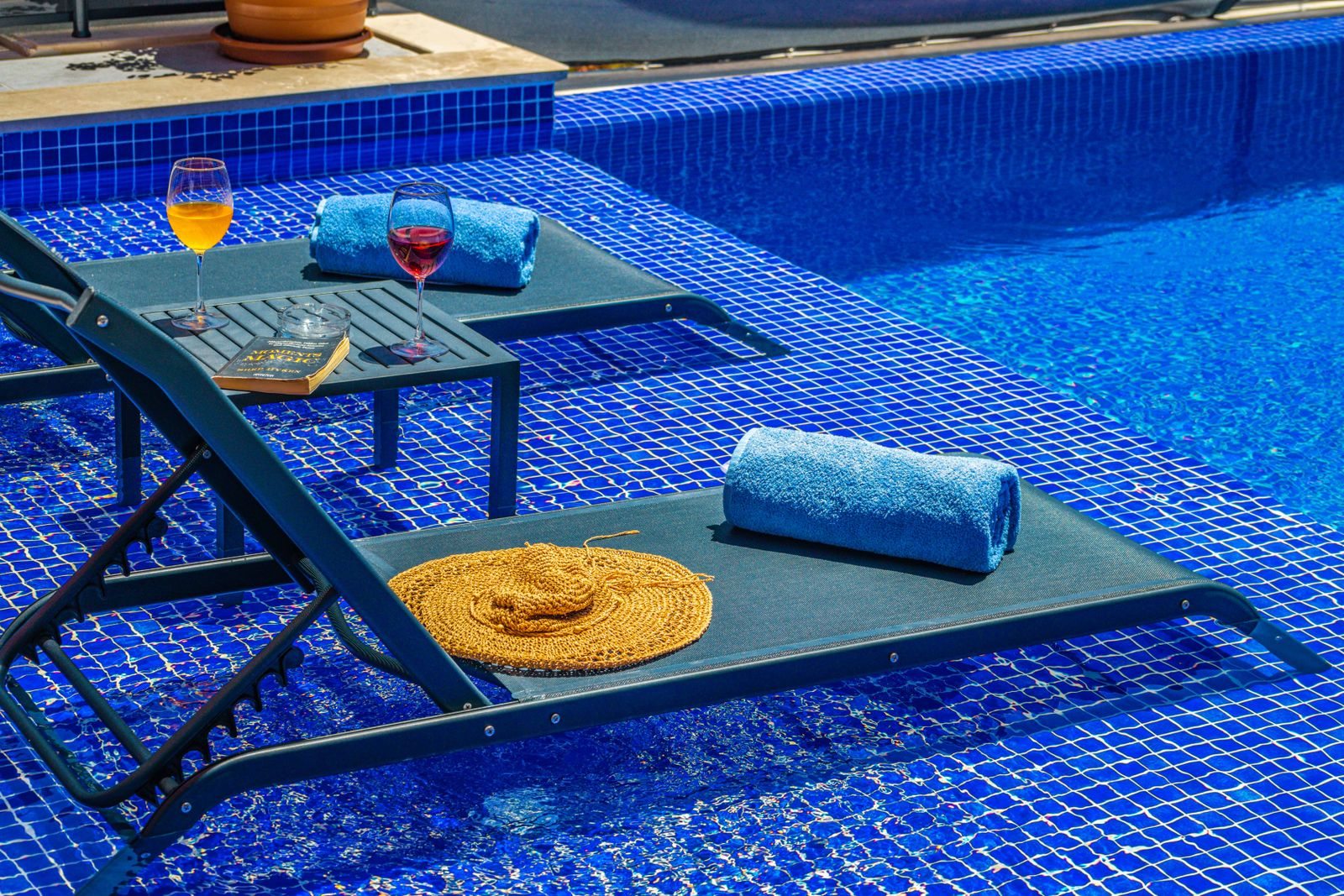 Due lettini con teli accanto all'acqua di una piscina